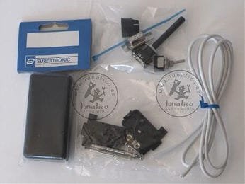 The parts laid out in their bags: a toggle switch with lever, a DB9 connector and its shell, a small project box, a length of cable and cable ties.