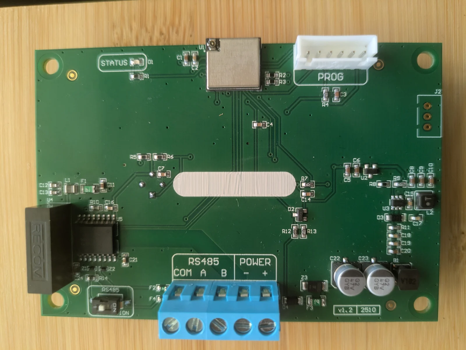 Component side of the CloudMonitor OEM board: five-way screw terminal marked RS485 COM A B and POWER minus plus, the RS-485 termination switch, an isolated DC-DC converter and the programming header
