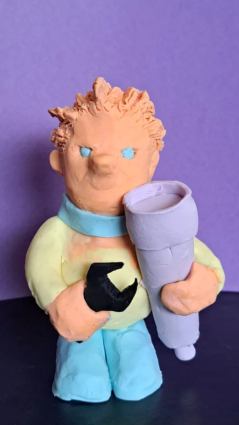 A clay sculpture of Cristobal holding a wrench and a telescope, by Bernardo