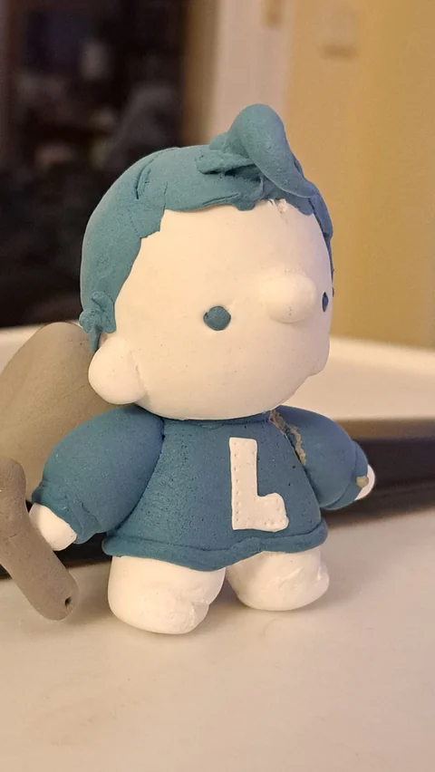 A clay figure of Cristobal wearing a jumper with an L patch, by Maria