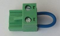 A short wire bridging the COM and IN terminals of a screw connector, used to push relay 1's button